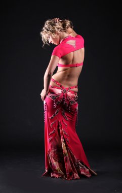 Beautiful belly dancer woman posing on black background clipart