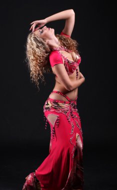 Exotic belly dancer woman posing on black background