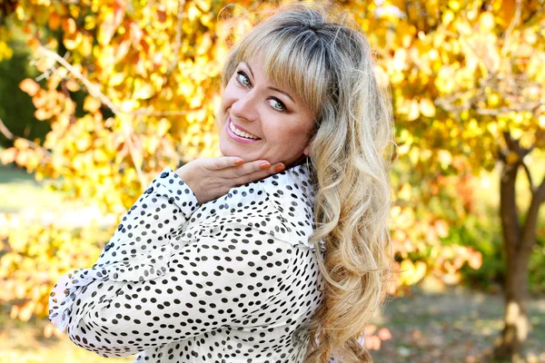 Feliz mulher sorridente sobre folhas de outono — Fotografia de Stock