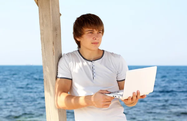 Young man with laptop look away at beach — Stock Photo, Image