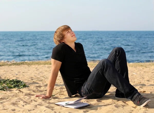 Knappe man ontspannen op het strand — Stockfoto