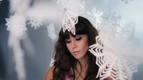 Young attractive brunette with paper snowflakes — Stock Photo, Image