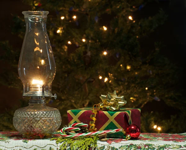 Christmas gift with lit oil lamp. — Stock Photo, Image