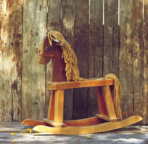 Old rocking horse on wood.