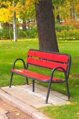 Bench in a holiday park in autumn clipart