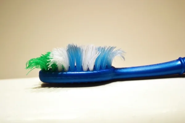 Gebrauchte Zahnbürste auf verschwommenem Hintergrund — Stockfoto