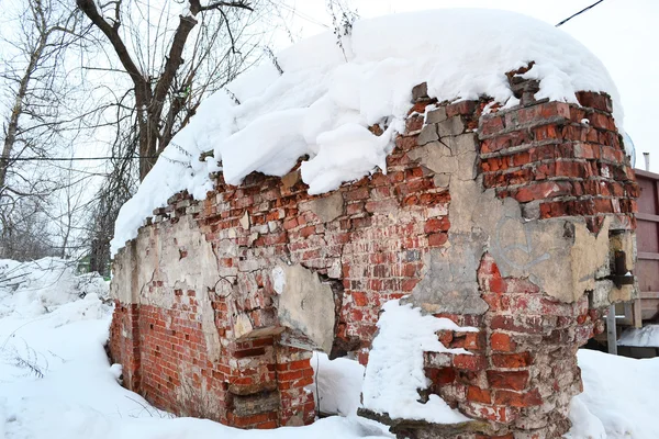 Старая кирпичная стена, покрытая снегом — стоковое фото