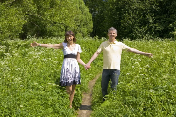 Jovem e mulher caminhando em um prado — Fotografia de Stock