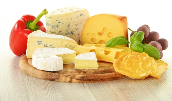 Složení s kousky sýra na prkénko na krájení — Stock fotografie