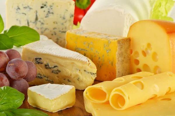 Composição com pedaços de queijo em tábua de pão — Fotografia de Stock