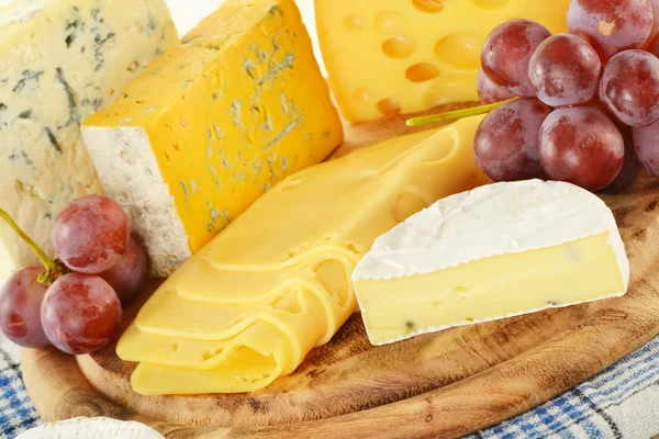 Složení s kousky sýra na prkénko na krájení — Stock fotografie