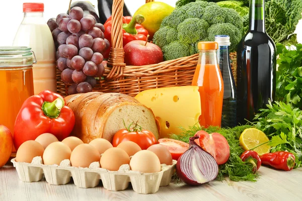 Boodschappen in rieten mand met inbegrip van groenten en fruit — Stockfoto