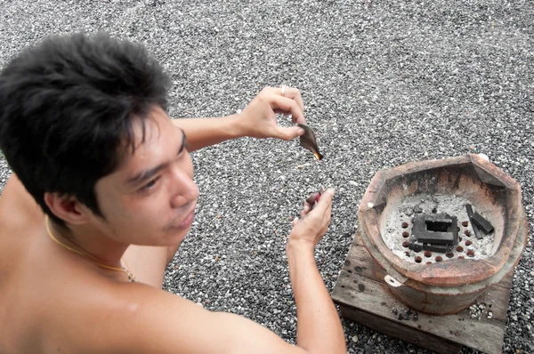 Aziatisch mens licht kolen kachel — Stockfoto