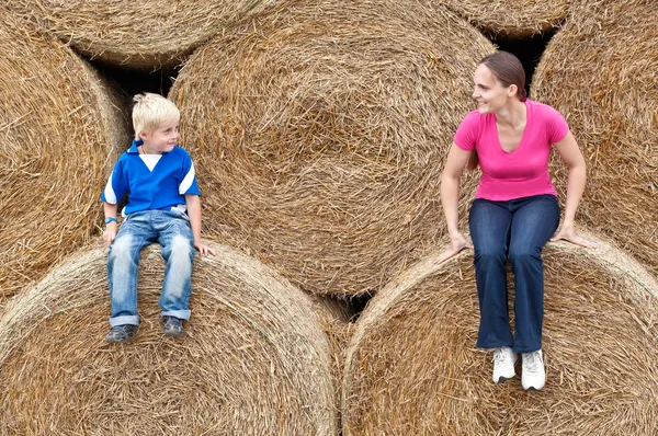 Jonge vrouw met zijn zoon op de hooibalen — Stockfoto