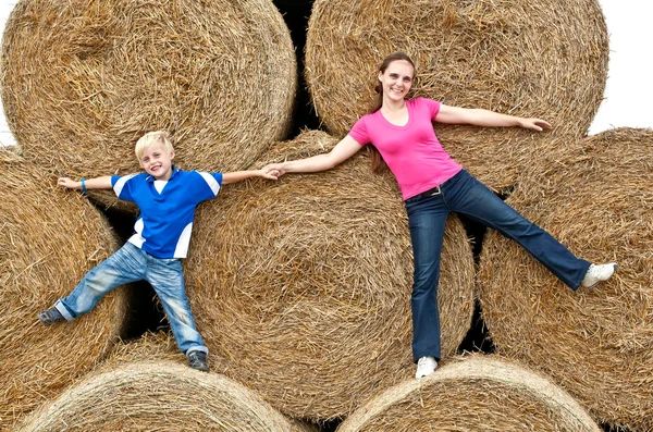 干し草の俵に彼の息子を持つ若い女 — ストック写真