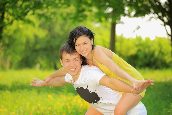 Felice giovane coppia godendo backriding all'aperto — Foto Stock
