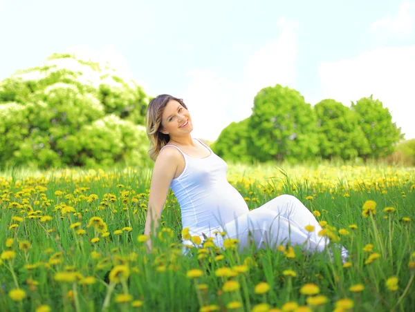 Femme enceinte assise sur la prairie — Photo