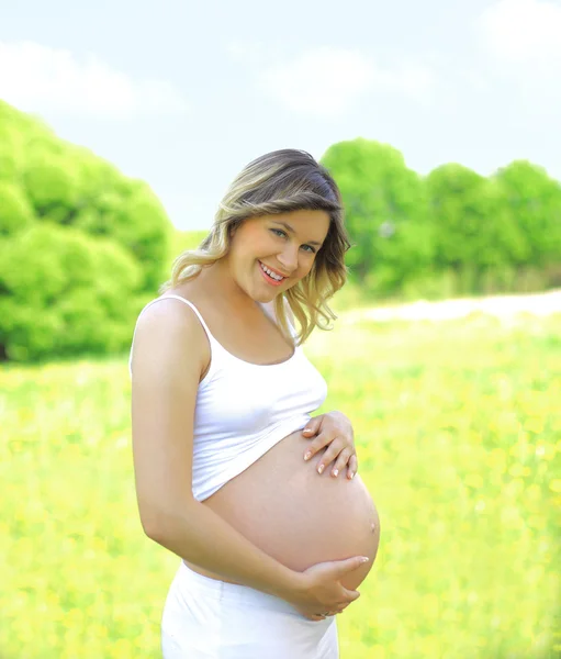 Красивая беременная женщина на лугу — стоковое фото