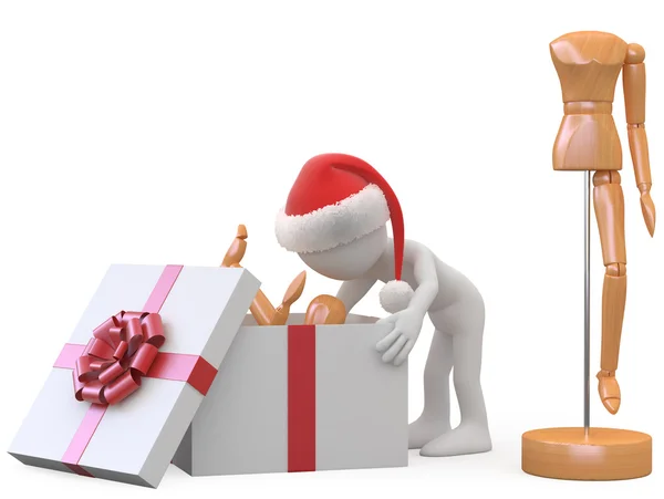 Uomo con cappello di Babbo Natale che tira fuori una bambola di legno di una scatola regalo — Foto Stock