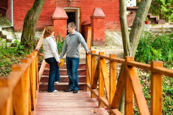 Romantic couple standing on wooden bridge — Stok fotoğraf