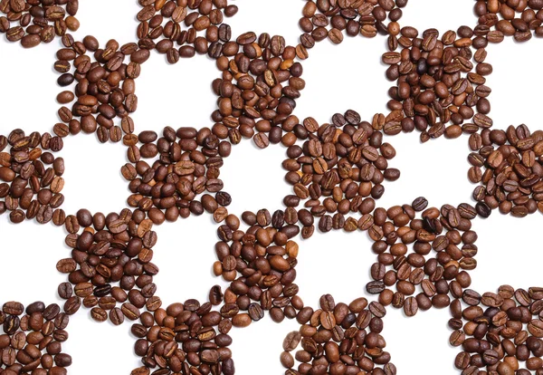 Кофейные зёрна на шахматном поле — стоковое фото