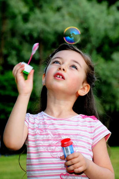 The little girl starts up soap bubbles — Stock Photo, Image