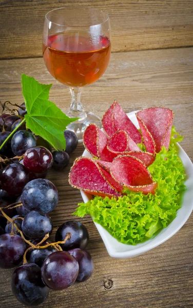 Salami de pimienta y racimos de uvas — Foto de Stock
