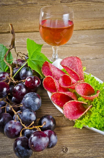 Peppar salami och klasar av druvor — Stockfoto