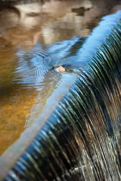 Pequeña piedra en el borde de una cascada en el arroyo — Foto de Stock
