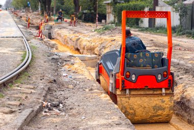 Roller ram the sand in the pit clipart