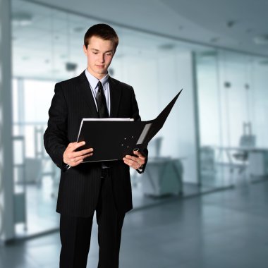 Young businessman reading documents at the office clipart