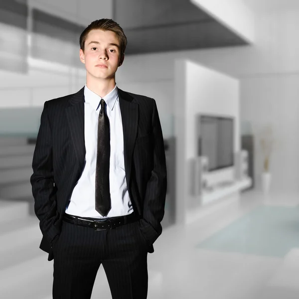 Ung framgångsrik affärsman står i ett modernt kontor — Stockfoto
