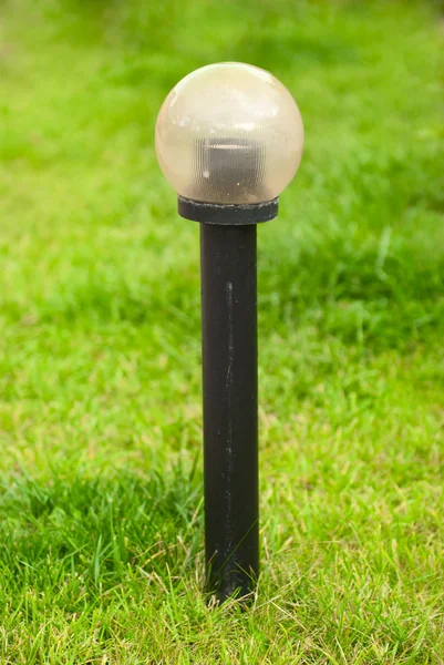 Lâmpada de jardim no fundo da grama verde — Fotografia de Stock