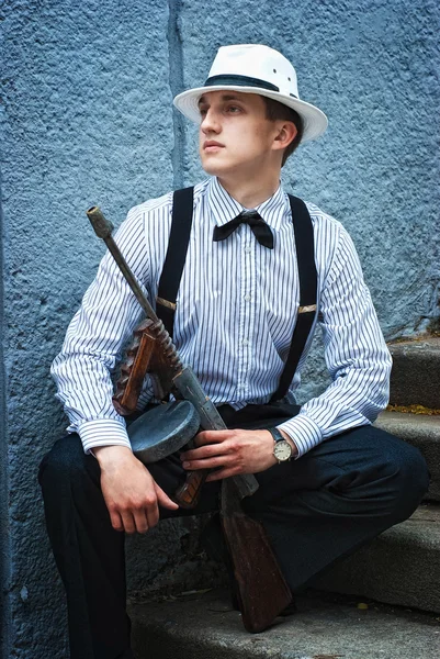 Young men in a hat and a suit holding gun — Stock Photo, Image