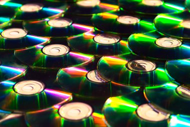 A lot of shiny cd discs lie on each other and shine clipart