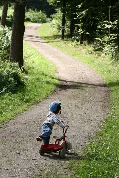 Niño jugando con su ciclo — Foto de Stock