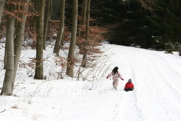 Criança brincando na neve — Fotografia de Stock