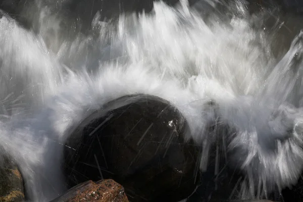 Вода розбризкується на каменях — стокове фото