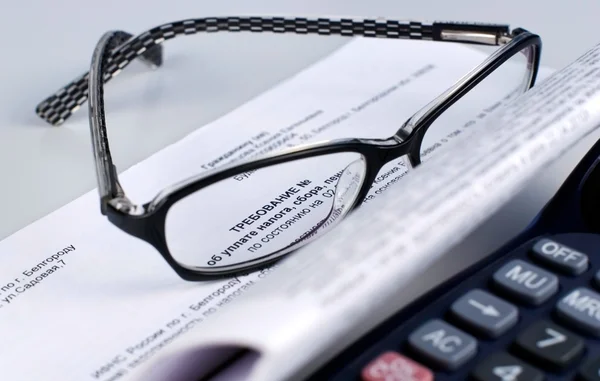 Document fiscal avec calculatrice et lunettes Images De Stock Libres De Droits