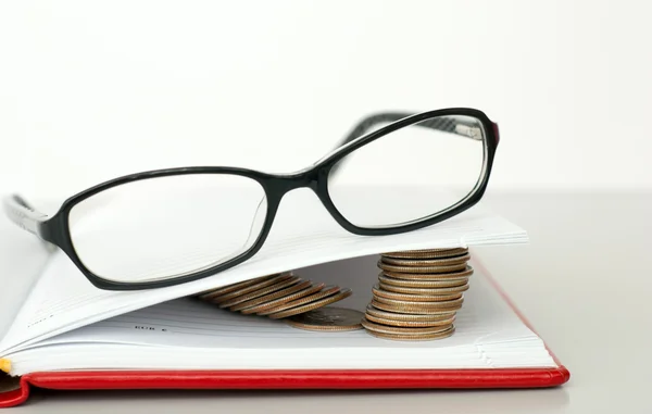 Brýle, kniha a mince — Stock fotografie