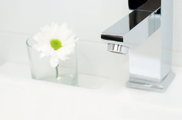 Хромова крана вода і квітка — стокове фото