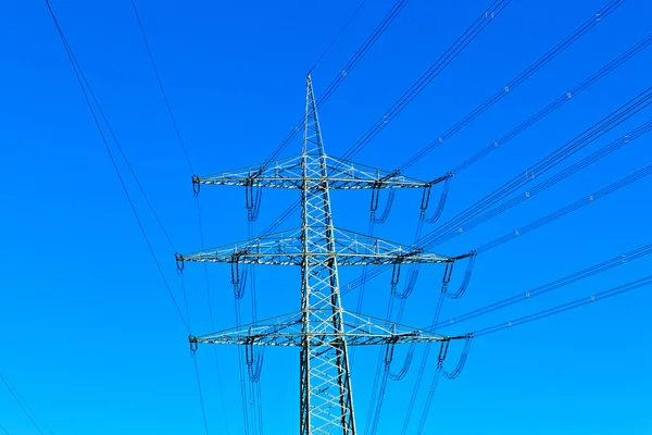 Steel electricity pylon on bright blue sky — Stock Photo, Image
