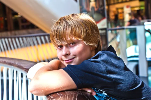 Rapaz sorridente dentro de um centro — Fotografia de Stock