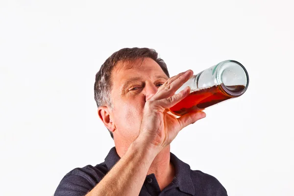 Человек, пьющий алкоголь из бутылки — стоковое фото