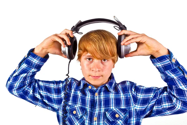 Rapaz feliz com fones de ouvido ouve música — Fotografia de Stock