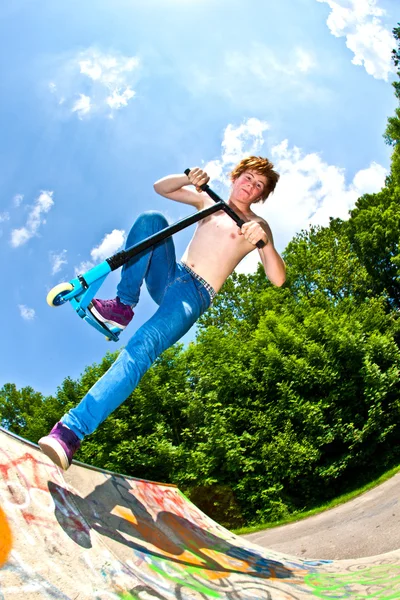 Giovane ragazzo in volo con uno scooter — Foto Stock