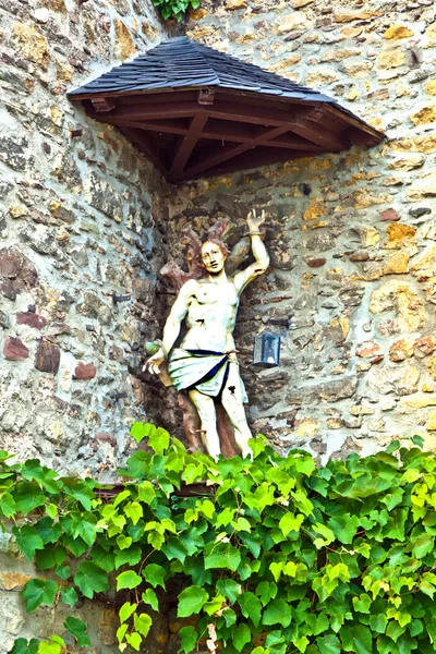 Статуя Иисуса на стене средневекового дома — стоковое фото