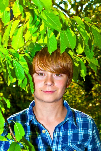 Portret ładny chłopiec w liście — Zdjęcie stockowe