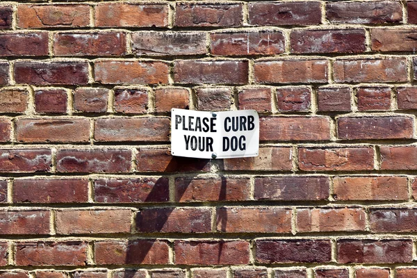 Sign please curb your dog at a house wall — Stock Photo, Image