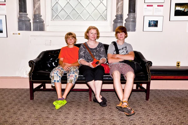 Семья, сидящая на скамейке у входа в Смитхонейскую музу — стоковое фото